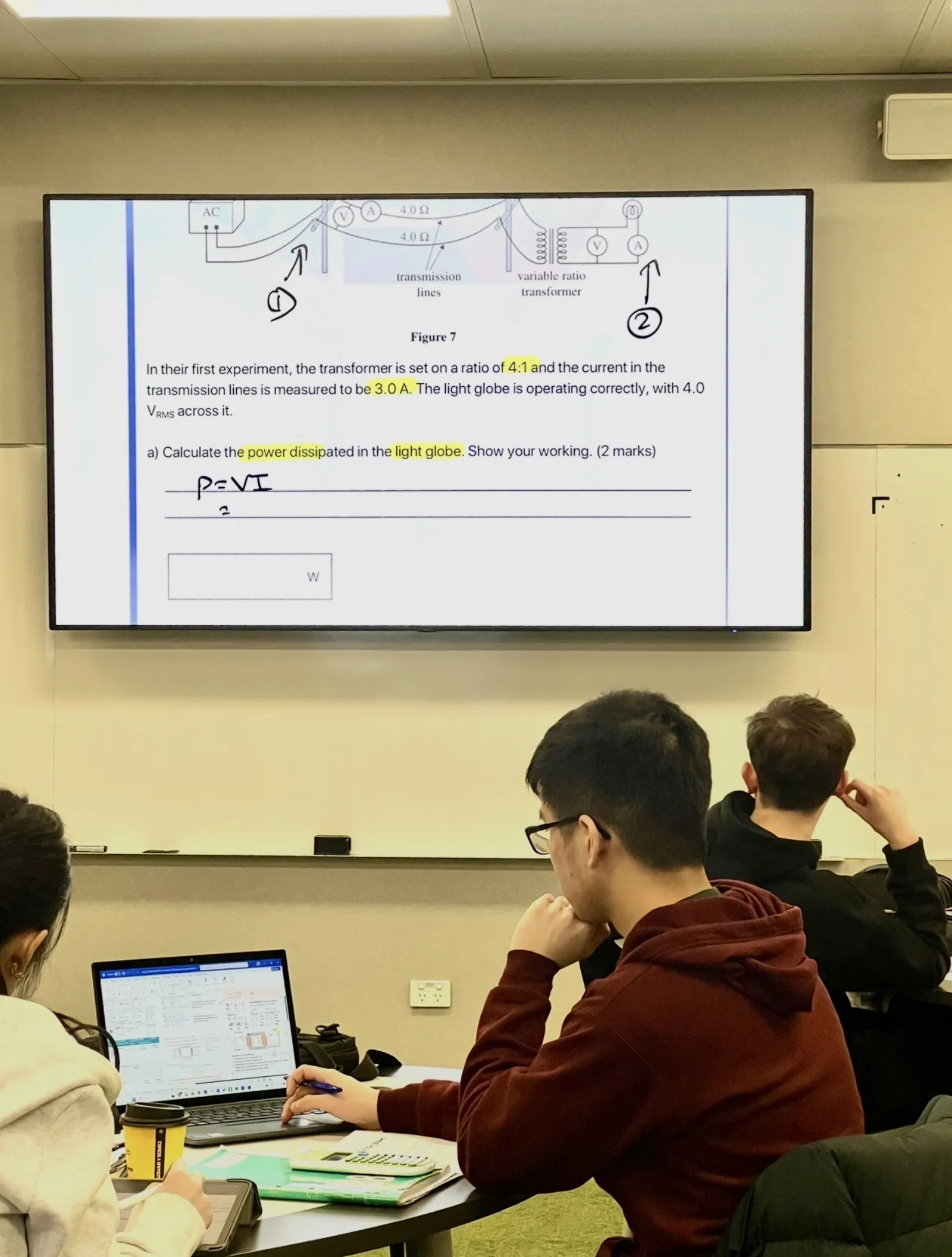 Student focused on a VCE Physics power generation exam question on screen